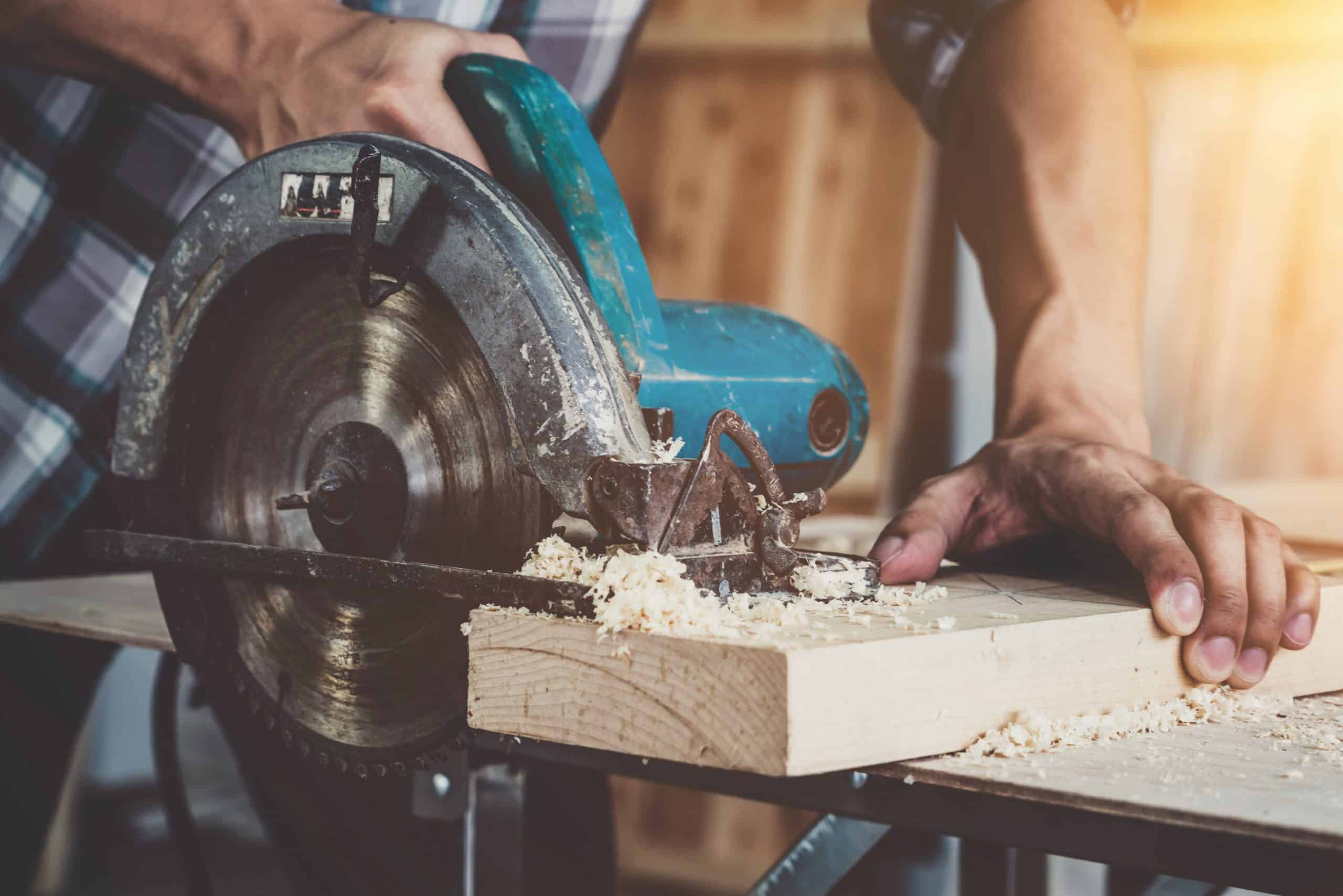Carpenter working on wood craft at workshop to produce construction material or wooden furniture. The young Asian carpenter use professional tools for crafting. DIY maker and carpentry work concept.
