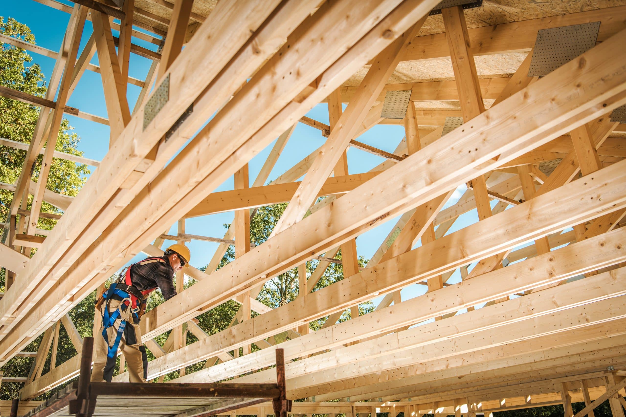 Construction Contractor Worker and the Wooden House Frame. Building Development.